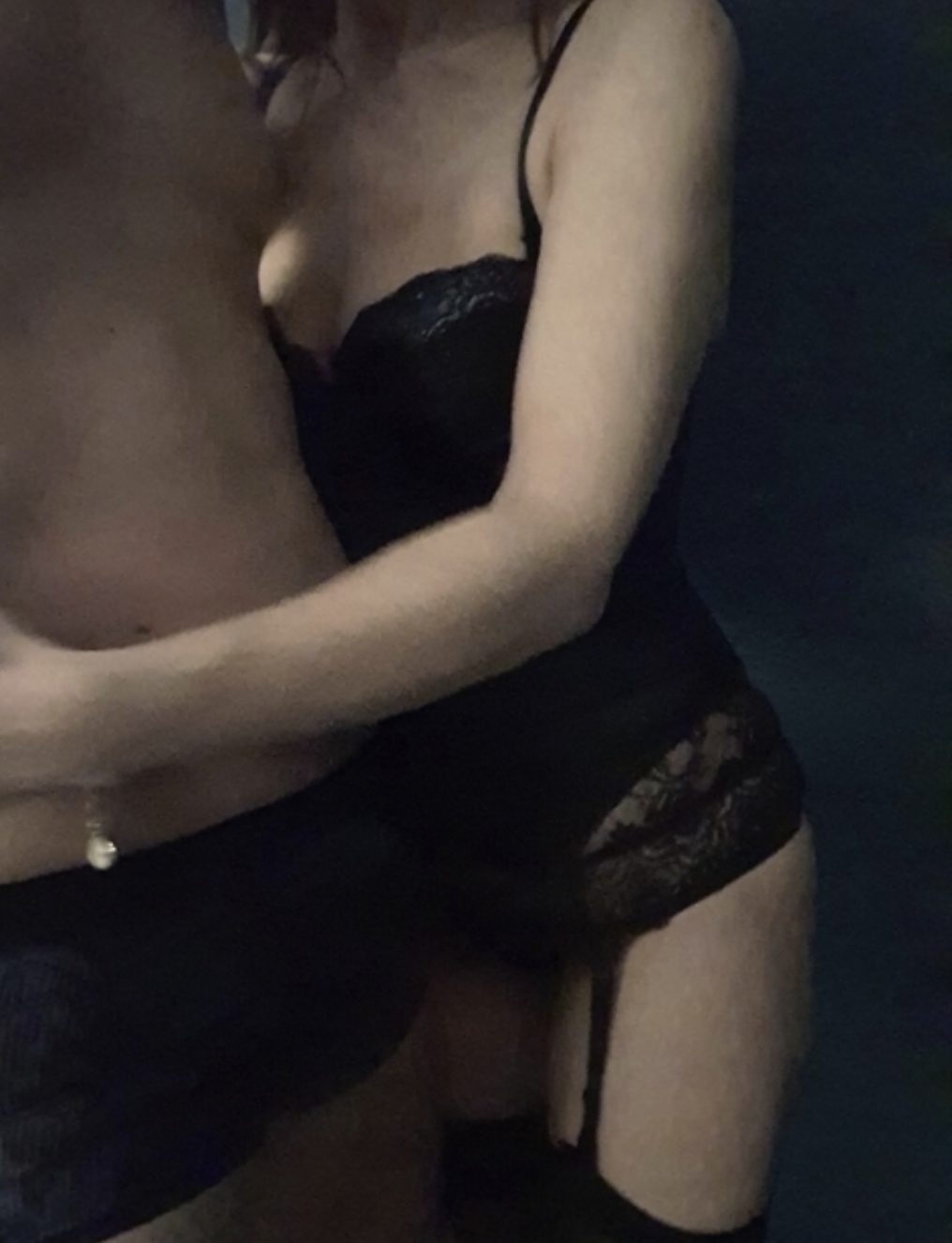 Rose en guêpière noire, dans les bras d'un homme.